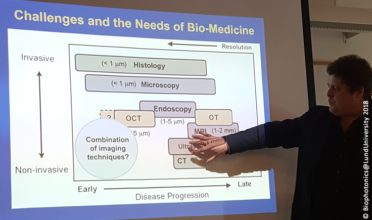 A researcher points at a power point with the title challenges and the needs for biomedicine 